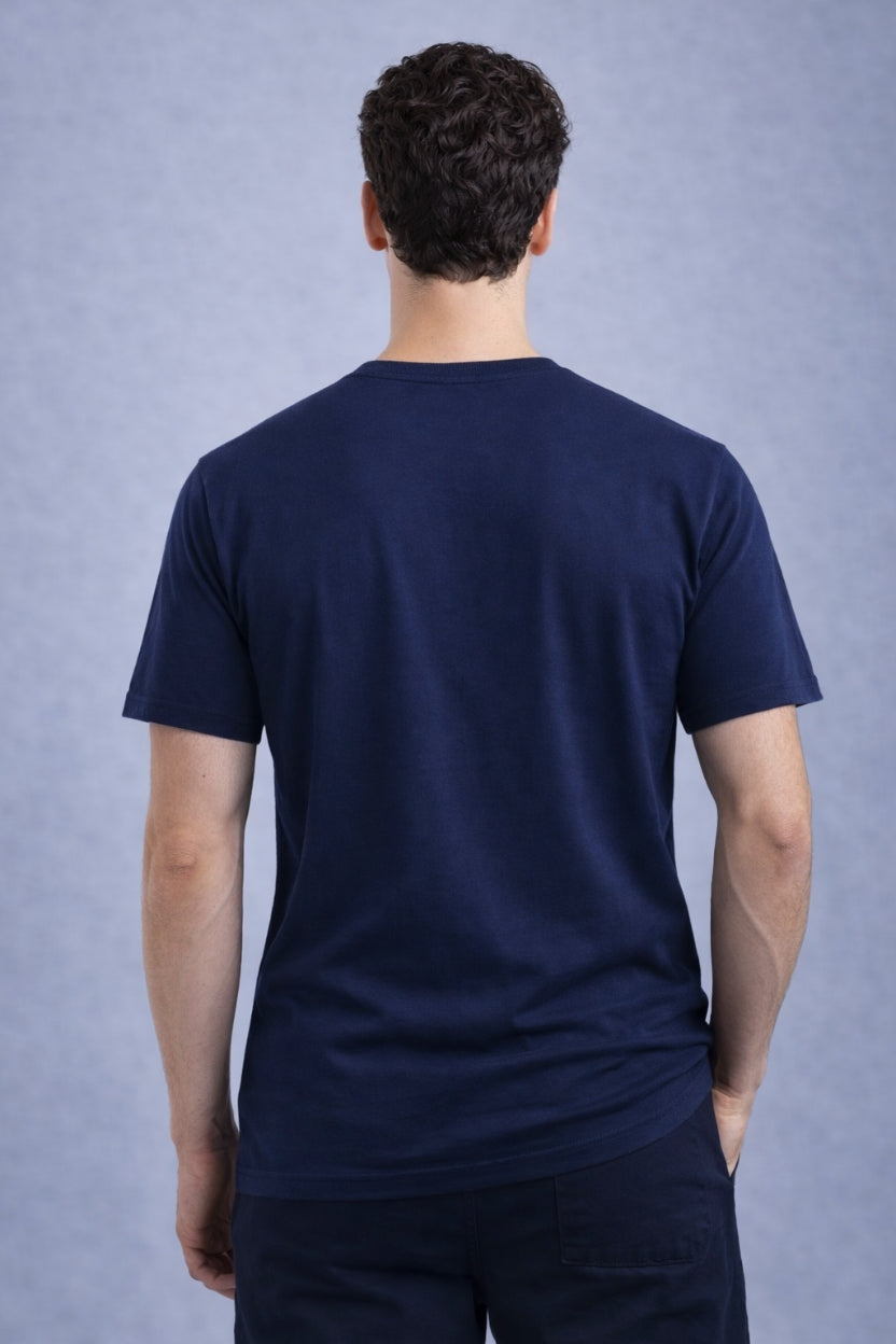 Person wearing a navy blue shreads relaxed fit t-shirt against a gray blue background